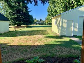 Longview house for rent - a backyard with a shed and a yard with grass and trees
