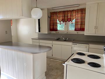 Longview house for rent - a kitchen with white cabinets and a stove and a sink
