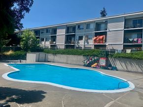 Longview apartment for rent - A blue swimming pool in front of a building.