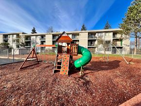 Longview apartment for rent - A playground with a green slide and a brown wooden structure.