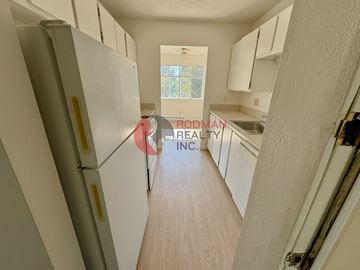 Longview apartment for rent - A kitchen with white cabinets and a refrigerator.