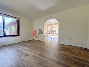 Longview house for rent - A room with wooden flooring and a sign that says "Rodman Realty Inc.".