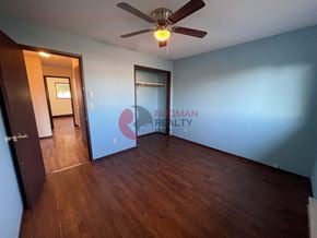Longview house for rent - A room with a ceiling fan and a door leading to another room.