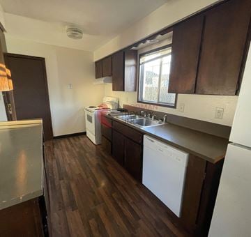 Longview house for rent - A kitchen with white appliances and brown cabinets.
