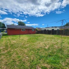 Kelso house for rent - A red barn sits in a grassy field with a cloudy sky above.