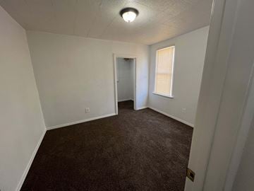 Kelso house for rent - a bedroom with a carpeted floor and a door to a closet