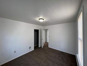 Kelso house for rent - an empty living room with white walls and a carpet
