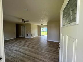 Kelso house for rent - an empty living room with wood floors and a ceiling fan