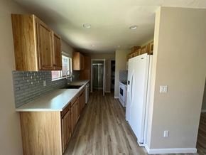 Kelso house for rent - a kitchen with white appliances and wooden cabinets