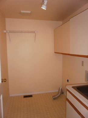 Longview house for rent - an empty kitchen with white cabinets and a sink