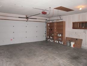 Longview house for rent - a garage with a white wall and shelves in it