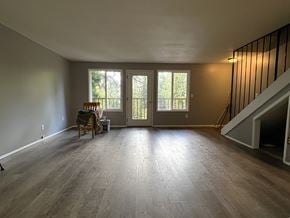 Longview apartment for rent - A room with wooden floors and a dining table with chairs.