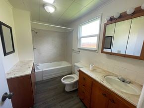 Longview house for rent - A bathroom with a toilet, sink, and bathtub.