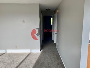Kelso apartment for rent - A hallway with a carpeted floor and a door at the end.