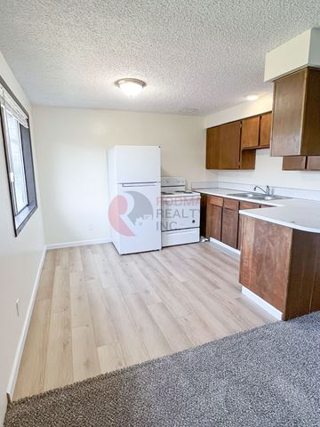Longview apartment for rent - A kitchen with a white fridge and wooden cabinets.