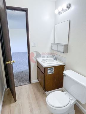 Longview apartment for rent - A bathroom with a toilet, sink, and mirror.