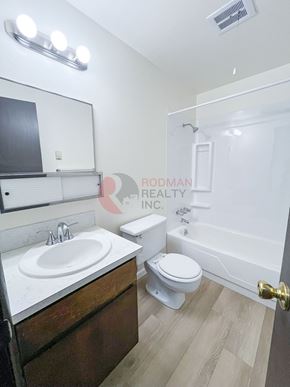 Longview apartment for rent - A bathroom with a toilet, sink, and mirror.