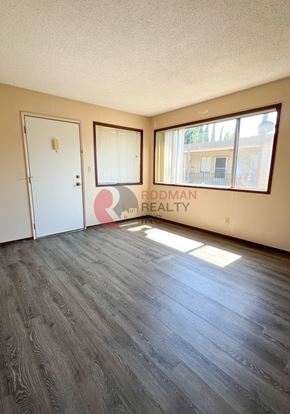 Longview apartment for rent - A room with a wooden floor and a window with a view of a building outside.