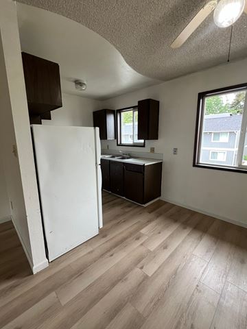 Longview apartment for rent - A kitchen with a white refrigerator and wooden floors.