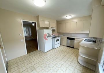Longview house for rent - A kitchen with a white fridge and a white dishwasher.