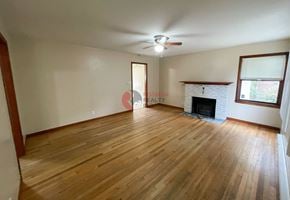 Longview house for rent - A room with wooden floors and a fireplace.
