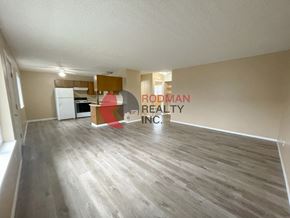 Longview apartment for rent - A spacious room with wooden flooring and a large window on the left side.