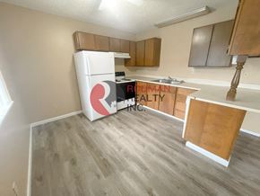Longview apartment for rent - A kitchen with a white fridge and wooden cabinets.