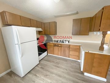 Longview apartment for rent - A white refrigerator is in a kitchen with wooden cabinets.