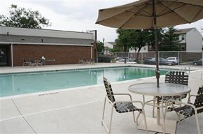 St. Louis apartment for rent - a swimming pool with a table with chairs and an umbrella