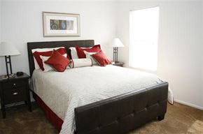 St. Louis apartment for rent - a bedroom with a bed with red and white pillows
