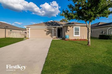 Middleburg house for rent - a beige house with a driveway and a tree