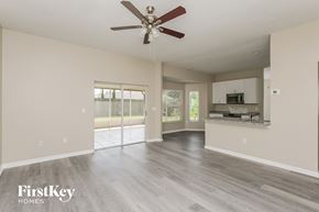 Brandon house for rent - A spacious living room with a ceiling fan and a kitchen area in the background.