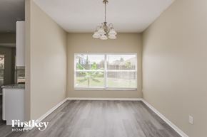 Brandon house for rent - A room with a large window and a chandelier hanging from the ceiling.