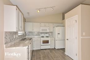 Imperial house for rent - a kitchen with white appliances and white cabinets
