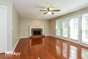 Kennesaw house for rent - A spacious living room with a fireplace and wood flooring.