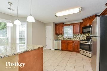 Kennesaw house for rent - A kitchen with a granite counter top and stainless steel appliances.
