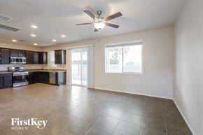 Tucson house for rent - an empty kitchen and living room with a ceiling fan