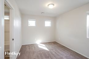 Tucson house for rent - a bedroom with white walls and white carpet and two windows