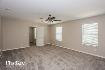 Monroe house for rent - a living room with carpet and a ceiling fan