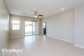 San Tan Valley house for rent - A spacious room with a ceiling fan and sliding glass doors.