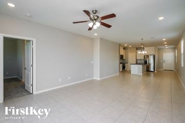 San Tan Valley house for rent - A spacious room with a ceiling fan and a kitchen in the background.