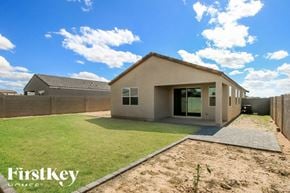 San Tan Valley house for rent - A house with a grey roof and a brown exterior is shown with a grassy yard in front.