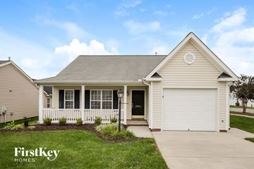 Winston Salem house for rent - the front view of a white house with a porch and a garage