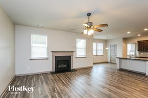 Hoschton house for rent - a living room with a fireplace and a ceiling fan