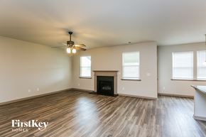 Hoschton house for rent - a living room with a fireplace and a ceiling fan