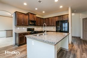 Hoschton house for rent - a kitchen with granite counter tops and wooden cabinets
