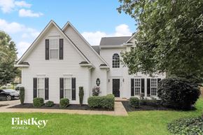 Charlotte house for rent - a white house with black shuttered windows and a lawn