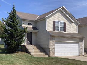 Lenexa apartment for rent - a tan house with a white garage door