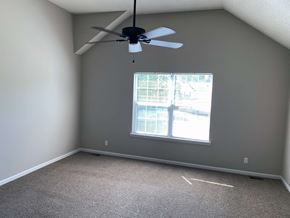 Lenexa apartment for rent - a bedroom with a ceiling fan and a window