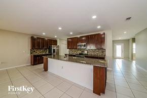 Palmetto house for rent - a kitchen with brown cabinets and a granite counter top
